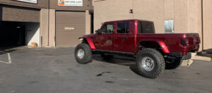 maroon Jeep truck has off road tires and driveshaft for the trails Arizona Driveshaft & Differential Mesa Arizona